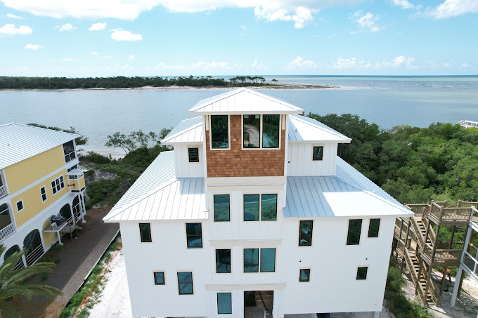 Elegant white standing-seam roof with modern dormers, built for coastal wind resistance and style.
